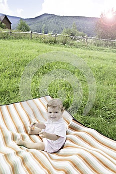 Cute little baby on the meadow in summer day