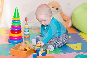 Cute little baby playing with colorful toys