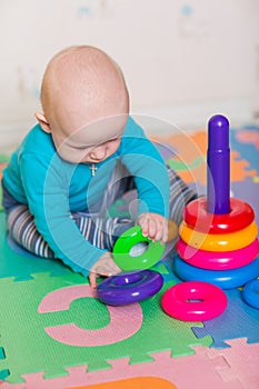 Cute little baby playing with colorful toys