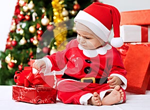 Cute little baby santa opening gift for christmas