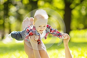 Cute little baby in summer park with mother on the grass. Swee