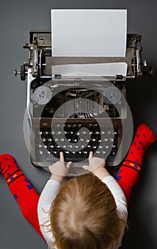 Cute little baby typing on typewriter