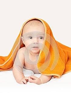 Cute little baby. Under bath towel. Happy kid portrait. White background