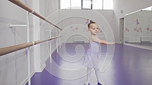 Cute little ballerina in leotard whirling in dance at ballet school