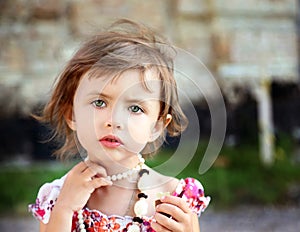 Cute little beautiful girl with chocolate in park photo