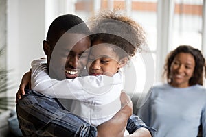 Cute little black girl embracing happy african american dad