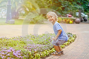 Cute little blond boy playing in the park smiling