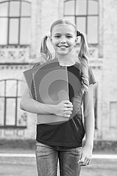 Cute little bookworm. Cute smiling small child hold books educational institution background. Adorable little girl