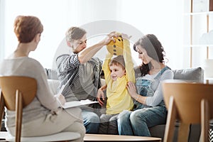 Cute little boy with ADHD during session with professional therapist photo