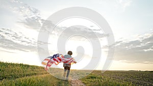 Cute little boy - American patriot kid running with national flag on open area countryside road.USA, 4th of July -