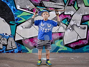 Cute little boy balancing a skateboard on his head