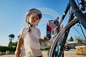 cute little boy with big bike outdoors in city street