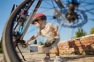 cute little boy with big bike outdoors in city street