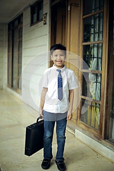 cute little boy bring suitcase acting like a businessman