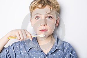 Cute little boy brushing teeth, isolated on white