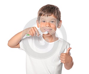 Cute little boy brushing teeth on white background