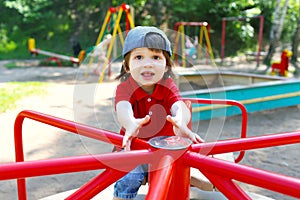 Cute little boy on carrousel in summer