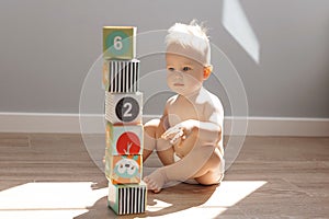 Cute little boy child playing at home with colorful cubes