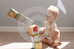 Cute little boy child playing at home with colorful cubes