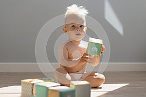 Cute little boy child playing at home with colorful cubes