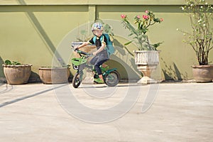 Cute little boy child wearing safety helmet learning to ride bike in sunny summer day at home, Kid cycling, Fun exercise for kids