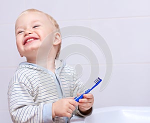 A cute little boy cleans his teeth