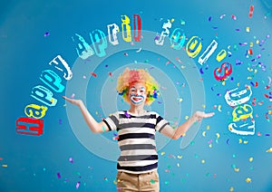 Cute little boy with clown makeup and falling confetti on color background. April fools\' day celebration