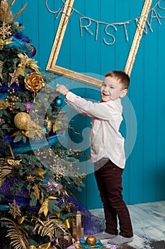 Cute little boy decorating christmas tree. Young kid in light bedroom with winter decoration. Happy family at home. Christmas New