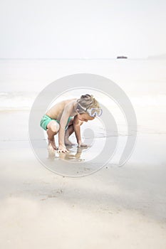 Cute little boy with diving glasses at the beach, thailand