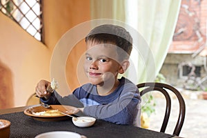 Cute little boy eating breakfast