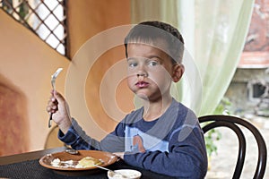 Cute little boy eating breakfast
