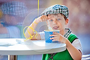 Cute little boy eating ice cream at indoor cafe