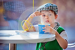 Cute little boy eating ice cream at indoor cafe