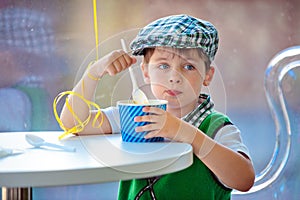 Cute little boy eating ice cream at indoor cafe