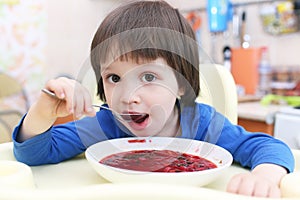 Cute little boy eating soup