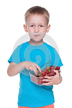 Cute little boy eats strawberry