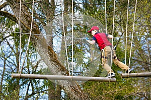 Cute little boy enjoying his time in climbing adventure park