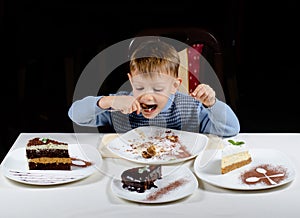 Cute little boy enjoying a treat of party cakes photo