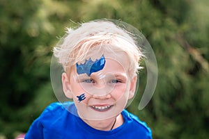 Cute little boy with face paint with batman pattern