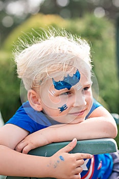 Cute little boy with face paint with batman pattern