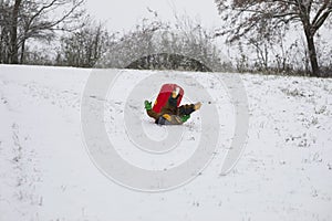 Cute little boy falling from his sleigh