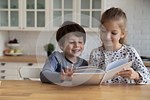 Cute little boy and girl reading fairy tale book together