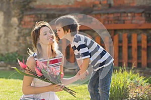 Cute little boy, giving present to his mom for Mothers day