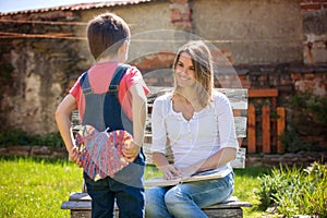 Cute little boy, giving present to his mom for Mothers day in th