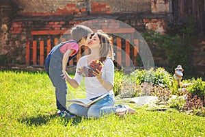 Cute little boy, giving present to his mom for Mothers day in th