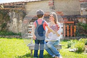 Cute little boy, giving present to his mom for Mothers day in th