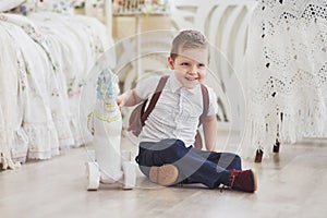 Cute little boy is going to school for the first time. Child with bag and book. Kid makes a briefcase, child room on a