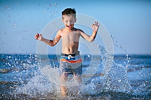 Lindo pequeno chico divirtiéndose sobre el Playa 