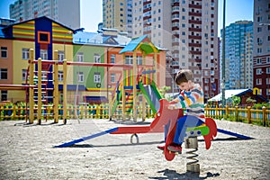 Cute little boy having fun on outdoor playground. Spring summer autumn active sport leisure for kids. Outdoors wooden equipment