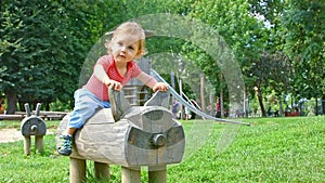 Cute little boy having fun playing with colorful wooden toys in the park, beautiful summer sunny day in children playground